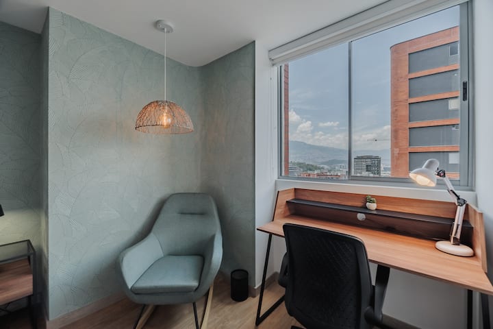 The master bedroom offers comfort and relaxation with an 85-inch Samsung TV, a spacious desk, air conditioning, blackout blinds, and elegant curtains. The luxurious Queen bed with premium linens is ideal for unwinding after exploring.