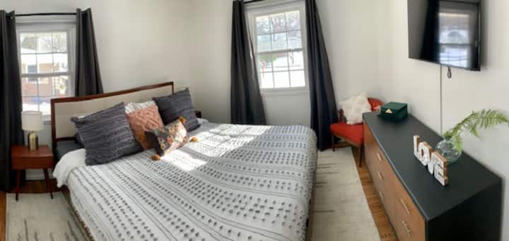 Шикозен комфорт в основната спалня: ново голямо двойно легло, рециклирани мебели и местно изкуство. Смарт телевизор, сензорни лампи и вентилатор на тавана с дистанционно управление. Спокойствието отговаря на практичността с скрин в пълен размер, килер и завеси за затъмнение.