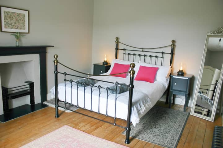 Elegant double bed, French style wardrobe, wooden floors, desk area and original fireplace in Bedroom 3, overlooking the back garden.