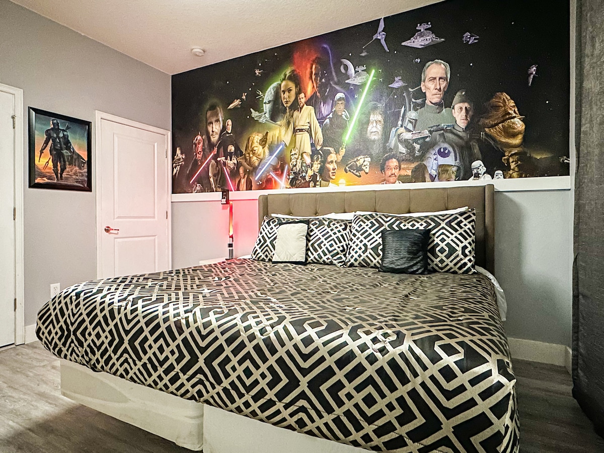 ¡Sumérgete en este santuario épico de Star Wars en Storey Lake! Una lujosa cama tamaño king con ropa de cama cósmica se encuentra debajo de un espectacular mural de Jedi vs. Sith. Una moderna lámpara de techo LED, un elegante tocador y unas cortinas opacas completan el ambiente de una galaxia muy, muy lejana