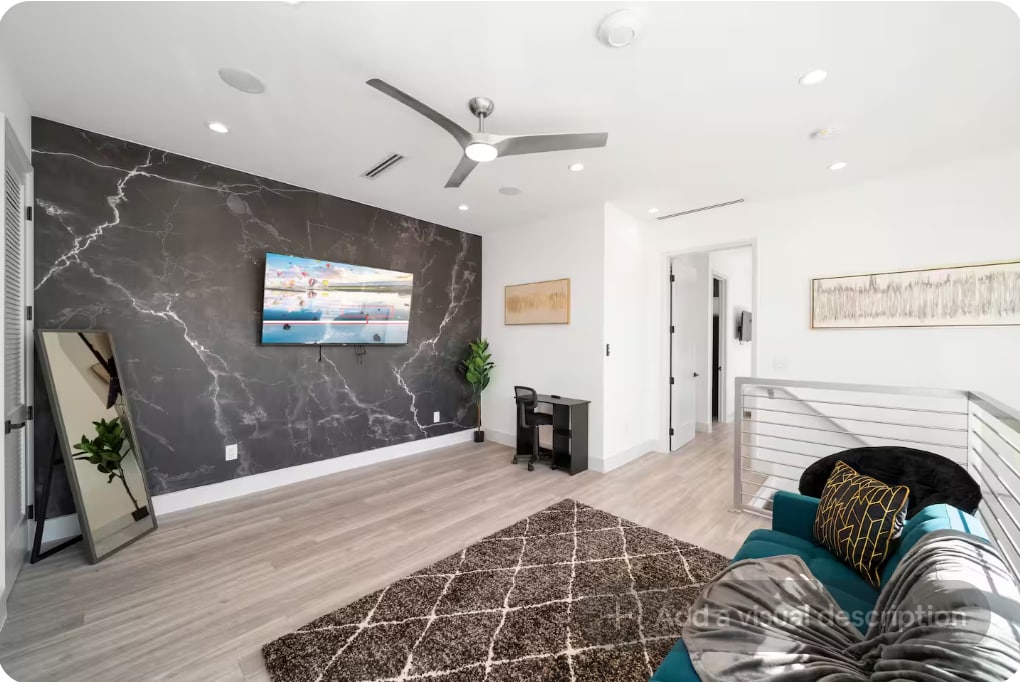 Salon de niveau supérieur avec canapé, télévision et mur décoratif moderne : un espace flexible pour se détendre ou se reposer tranquillement