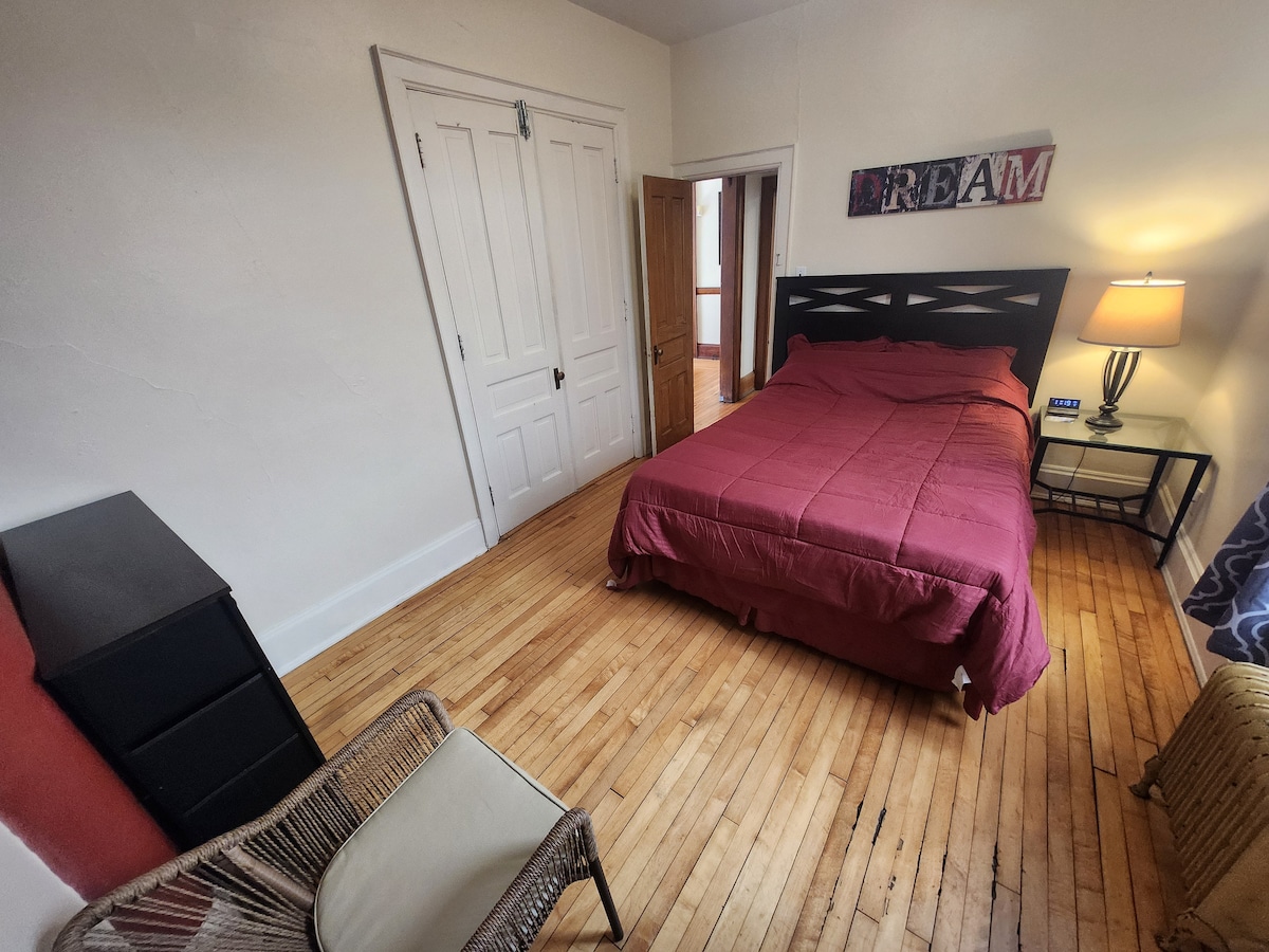 主卧配有标准双人床、梳妆台、衣柜、床头柜、台灯、无线充电器/时钟，配备额外的毯子和熨斗/熨衣板。