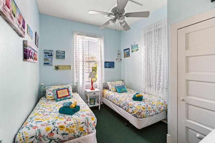 ¡Dos camas individuales con TV montada en la pared y ventilador de techo en el cuarto dormitorio!