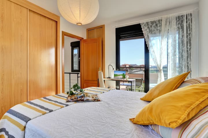 غرفة نوم في الطابق العلوي، مع إمكانية الوصول إلى تراس مع أرجوحات شبكية 