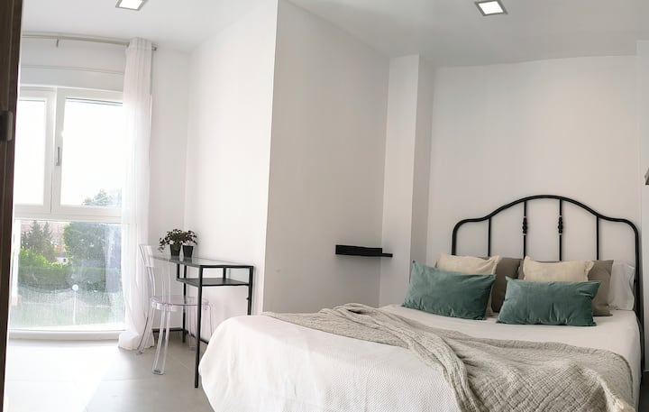 Двойна спалня с изглед към градината, големи прозорци