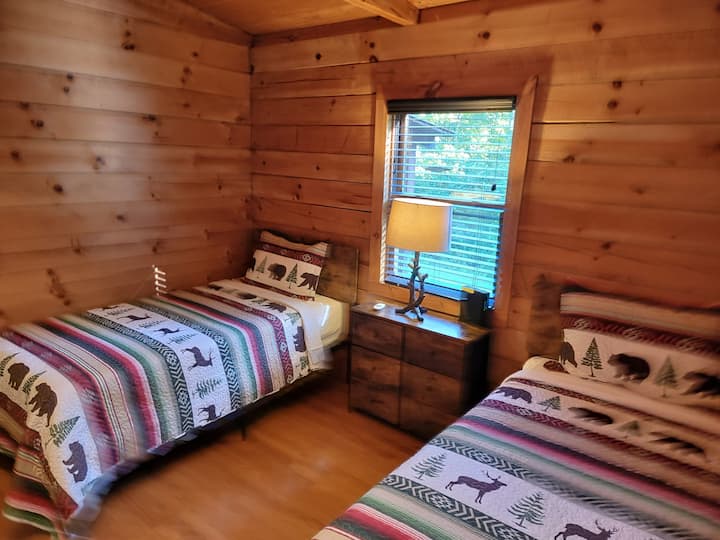 ห้องนอนคู่ที่ Black Bear Cabin มีเตียงคู่ที่สะดวกสบาย 2 เตียง เหมาะสำหรับเด็กหรือเพื่อน ด้วยผ้าปูที่นอนที่อบอุ่นและบรรยากาศที่อบอุ่นและเรียบง่าย ที่พักที่มีเสน่ห์แห่งนี้มอบการพักผ่อนที่สงบหลังจากสำรวจมาทั้งวัน