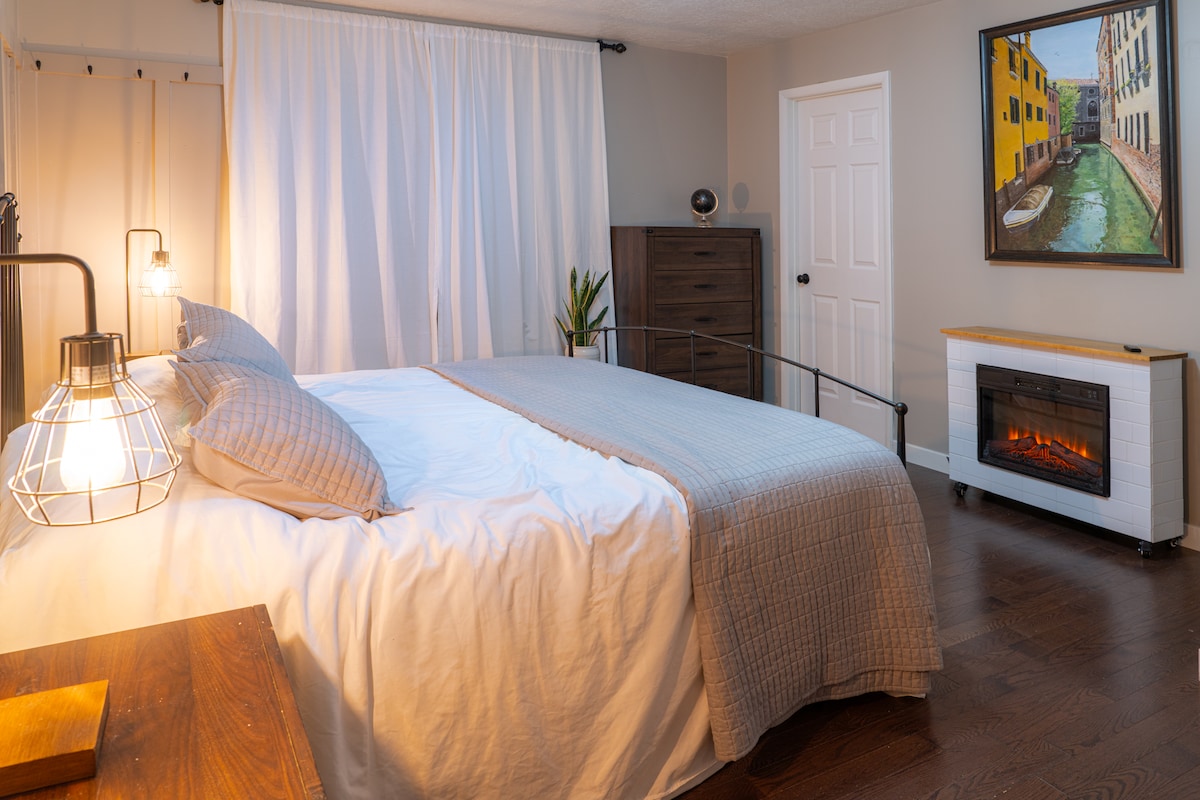 Primarna spavaća soba na katu s električnim kaminom, spojenom kupaonicom i bračnim krevetom u Caliju