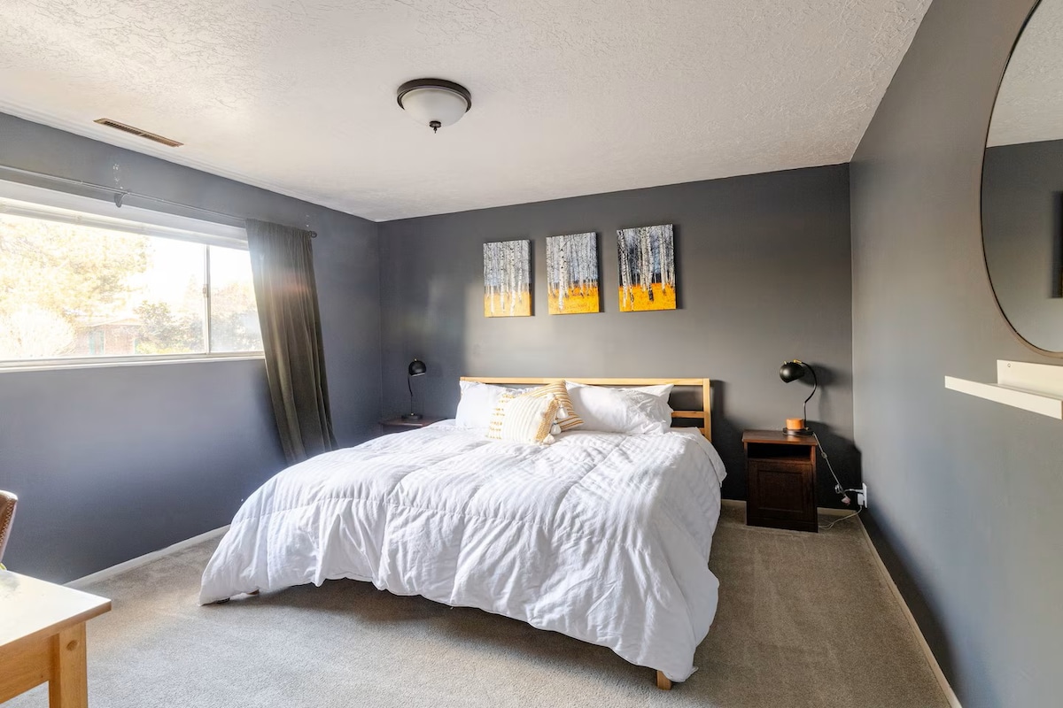 Primarna spavaća soba u podrumu s zavjesama za zamračivanje, radnim stolom i bračnim krevetom