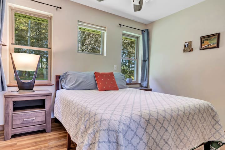 Главна спална соба со брачен кревет (широк 150-179 см) и поглед кон три прозорци.