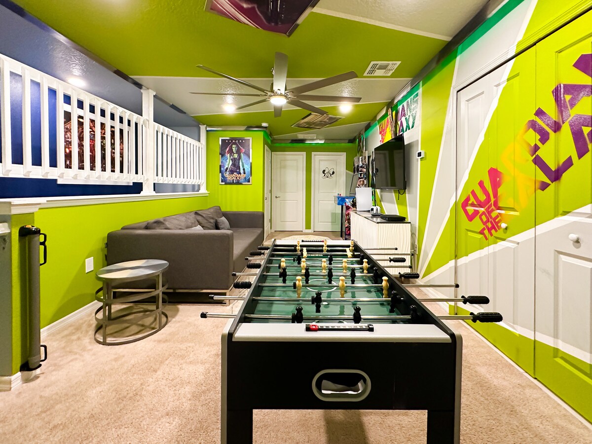 Ჩაყვინთეთ ამ Guardians-ის მიერ შთაგონებული თამაშების თავშესაფარში: ძლიერი ცაცხვის კედლები და დახრილი ჭერის პანელები ბრწყინავს RGB LED მორთვის ქვეშ, ხოლო გლუვი ნაცრისფერი სექციური, ფოსბოლის მაგიდა, რეტრო არკადული აპარატები და ანტრესოლით გასეირნება უსაზღვრო მხიარულებას იწვევს.                       