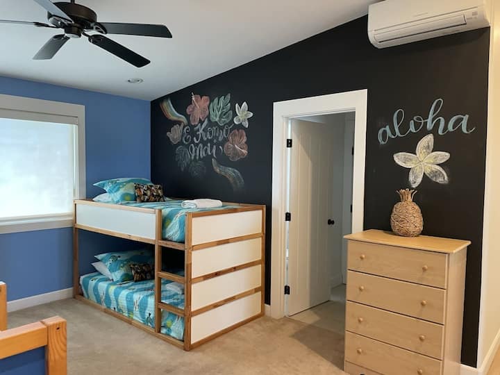 חדר קייקי בסגנון פתוח עם 2 מיטות קומותיים וקיר לוח.