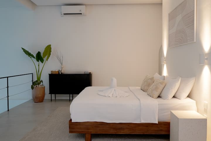 Ova moderna i čista soba ima visoke stropove i obilje prirodnog svjetla, stvarajući svijetlu i prozračnu atmosferu