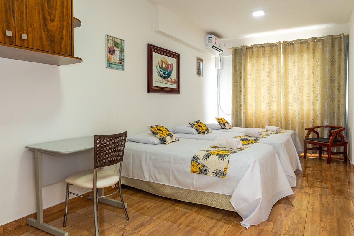 Ოთახი 2 3 ერთადგილიანი საწოლით  და სამუშაო მაგიდით სამუშაო სკამით. Ეს  ოთახი სამხრეთ ბაჰიის ზღვას გადაჰყურებს კიდევ ორი სკამით.  Საკონფერენციო და ხიდის ცენტრი. Ponte Her.Luz. Florianopolis Postcard.