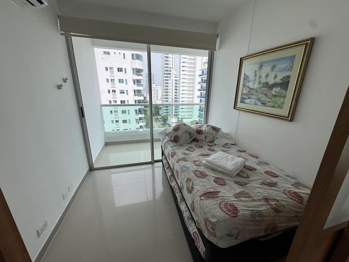 Მყუდრო დამხმარე ოთახი ბუდის საწოლით, A/C ‑ ით და აივანზე პირდაპირი გასასვლელით. Იდეალურია დამატებითი სტუმრისთვის, ქალაქის ხედით და ბუნებრივი განათებით, რომელიც დასასვენებლად გიწვევთ.