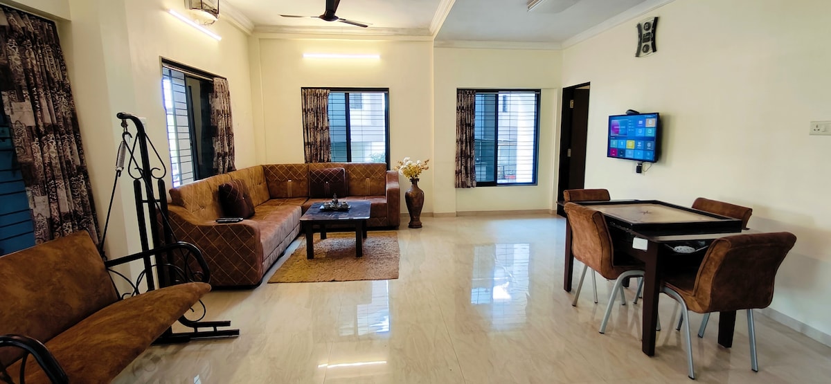 סלון עם ספה, שולחן אוכל, נדנדה, טלוויזיה חכמה LED, מערכת מוזיקה, קישוריות Wi - Fi.