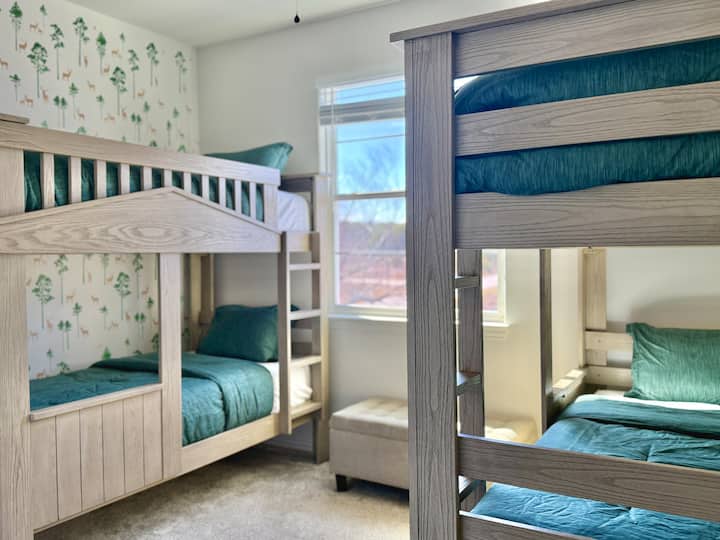 ¡Una acogedora habitación con literas con camas rústicas de madera, lujosa ropa de cama verde y un encantador ambiente de bosque! ¡Perfecto para una estancia cómoda y divertida!