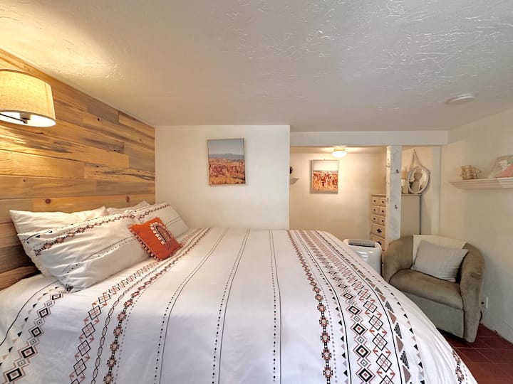 El cuarto dormitorio, una suite privada, se encuentra por separado de la casa principal. Accesible a través del patio en la parte trasera de la propiedad, esta suite privada cuenta con una cama tamaño queen, un baño privado, una cómoda, una silla y un televisor inteligente.