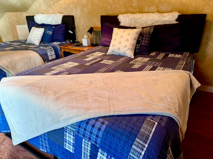 This private loft is situated at the front of the cabin. It blends coziness and fun for the ultimate experience! With two queen beds, the loft accommodates up to 4 guests.