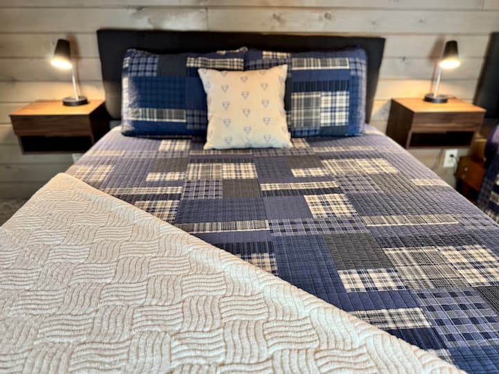 Climb the wooden ladder to discover our private lofts at North Shore Vacation Rentals' Briar Lake Lodge! These lofts bring the magic to life and are perfect for families. Each loft features two queen beds, complete with bedside tables and lamps. 