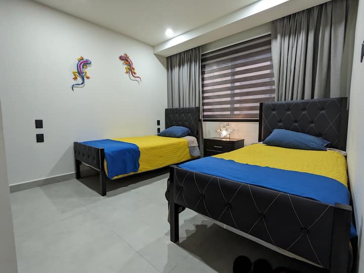 Second bedroom with two single beds that convert into a king-size bed.