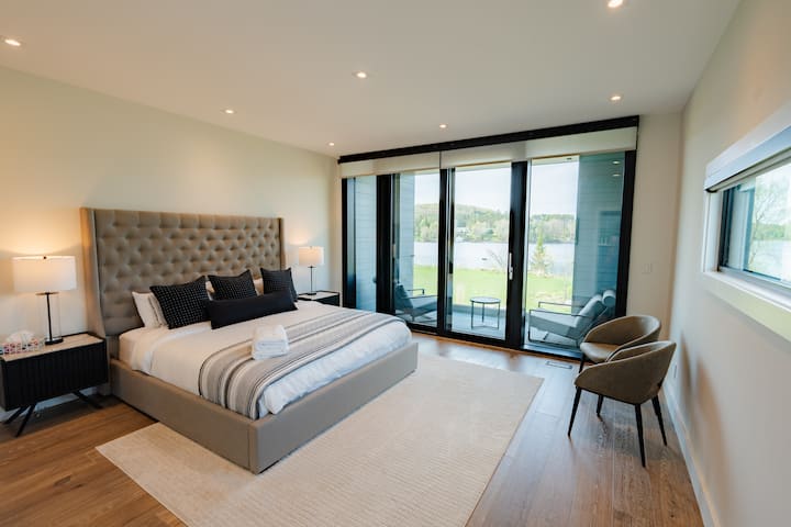 Спалня за гости на мецанин с двойно легло, самостоятелна баня, отделен покрит балкон с изглед към езерото Феъри, дрешник и дистанционно управлявани щори за уединение.