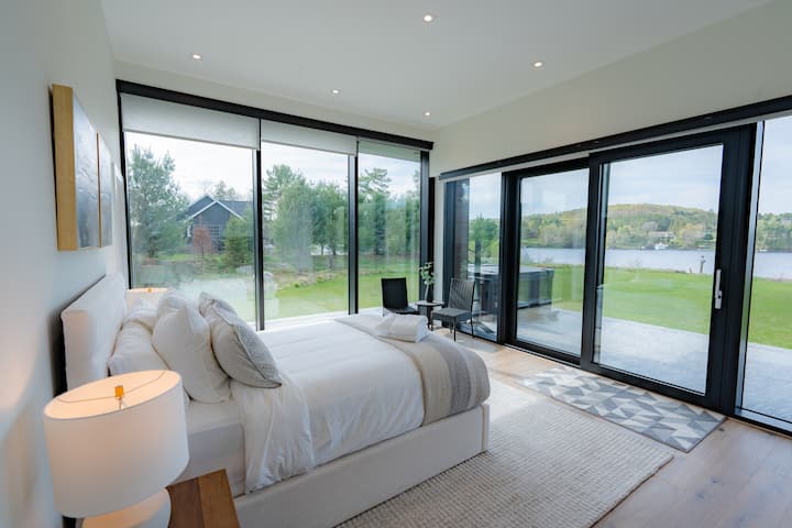 Просторна стая за гости на основния етаж с двойно легло, дистанционно управляеми щори за уединение, самостоятелен санитарен възел и дрешник. Чудесен вариант за всеки, който има проблеми с достъпността. Директен достъп до хидромасажната вана и вътрешния двор с плъзгащи се врати. 55-инчов смарт телевизор.