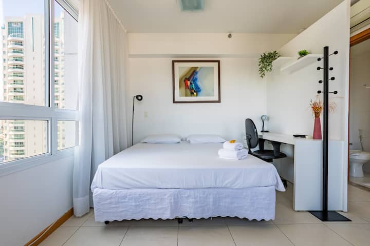 Habitación con cama tamaño queen, aire acondicionado, TV, ropa de cama, apagón en las cortinas, plancha y un lugar para guardar ropa.