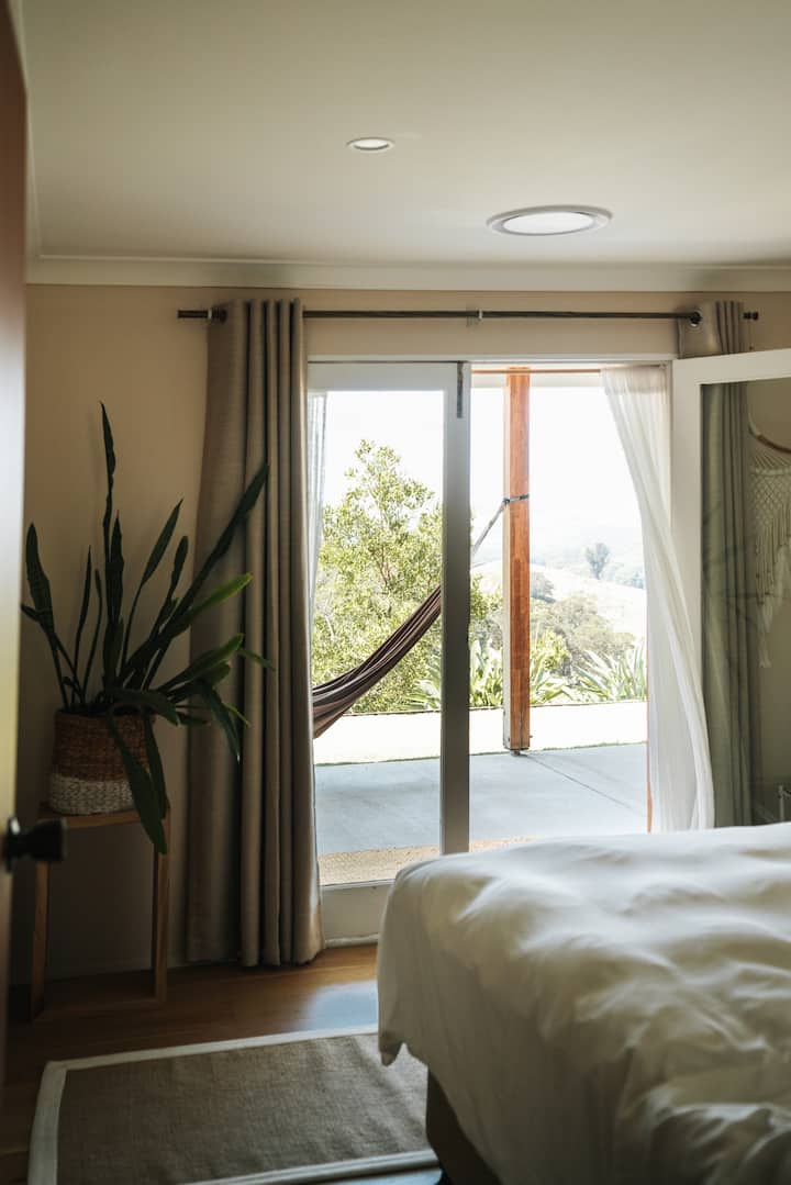 Las puertas francesas dan al valle y saludan al sol, la habitación se puede configurar con una gran cama tamaño king o dos camas individuales tamaño king divididas, viene con un pequeño espacio para colgar abrigos de bambú