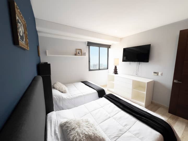 Chumba cha pili kina televisheni na vitanda 2 kwa ajili ya starehe ya wageni. 