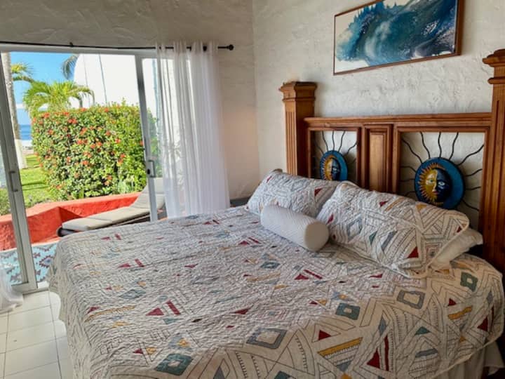 ห้องนอนคาสิตาคิงไซส์ที่ได้รับการตกแต่งอย่างสวยงามพร้อมห้องน้ำส่วนตัว  มีวิวสวนและมหาสมุทรจากประตูกระจกบานเลื่อนออกไปยังลานส่วนตัว 