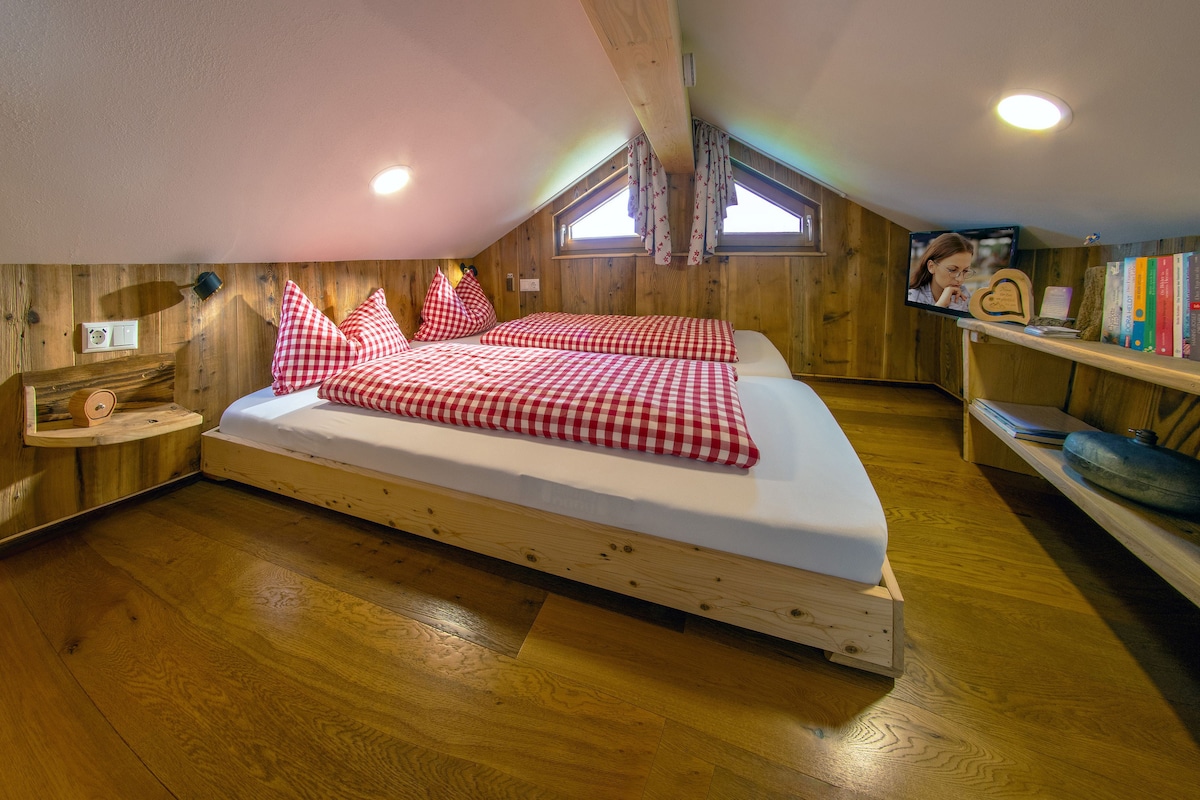 Een trap leidt naar dit slaapgedeelte. Een smart-tv, een kleine bibliotheek, een selectie geuroliën en meer staat voor je klaar