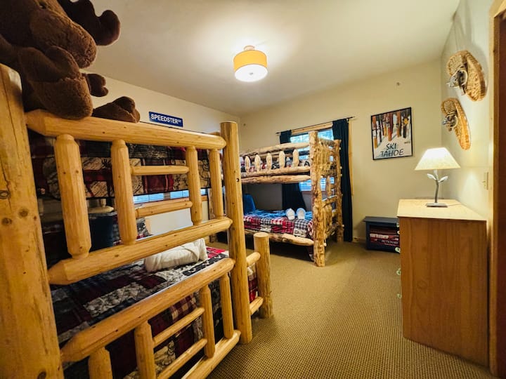 Habitación para niños con dos literas de madera personalizadas: una es una combinación completa/doble y la otra es doble.