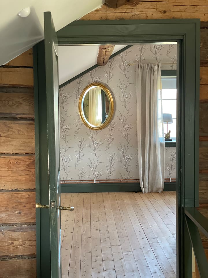 Välkommen in i Sovrum 1. Det största sovrummet, som ligger på andra våningen Här sover du i en dubbelsäng i ett rymligt rum med fönster i tre väderstreck. 