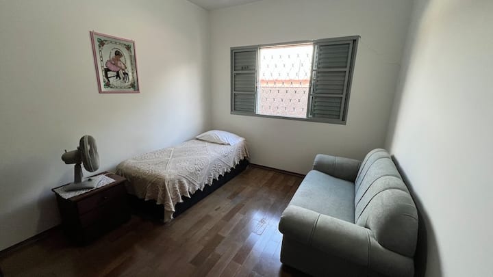Quarto 2 com ventilador, cama de solteiro e um sofá