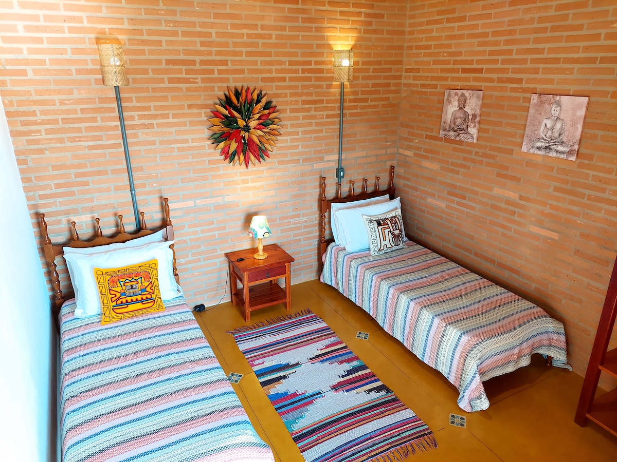 חדר יחיד עם מיטות עץ, מנדלה צבעונית ופמוטי במבוק בעבודת יד יוצרים אווירה נוחה ונעימה. ליהנות משלווה על ידי מנוחה והתפעלות מנוף ההרים, עם כל מה שנמצא בטווח הראייה שלכם