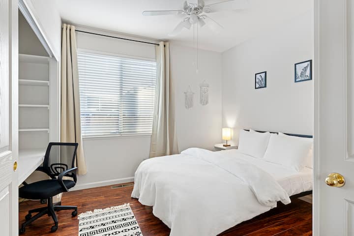 غرفة نومنا في الطابق السفلي مع سرير بحجم كوين تتضاعف كمساحة مكتبية أيضًا.