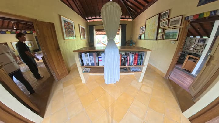 Mwonekano wa pana wa chumba cha kulala, na sebule kwenye upande wa kushoto na bafu kwenye upande wa kulia.