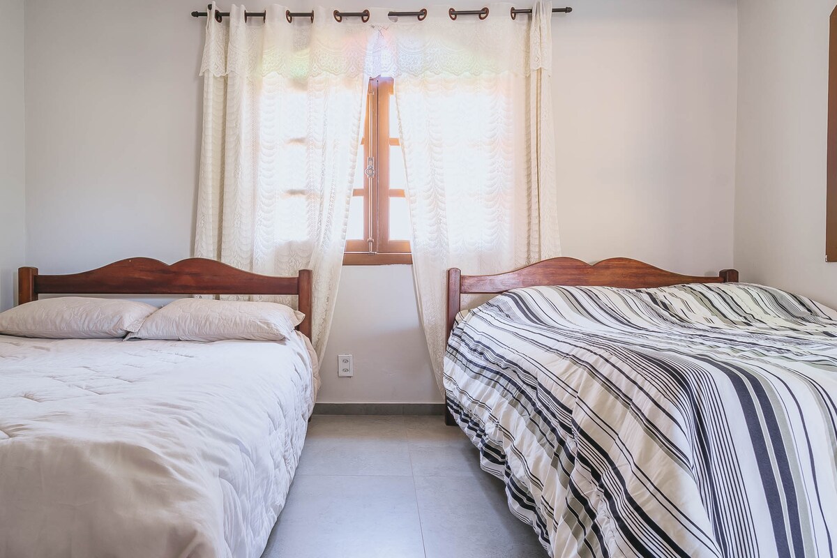 Habitación 5 con 2 camas de matrimonio + ventilador de techo + aire acondicionado. Está en el segundo piso de la casa.