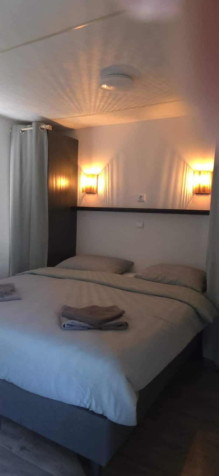 Las camas están hechas y la habitación tiene un ambiente de iluminación completa.