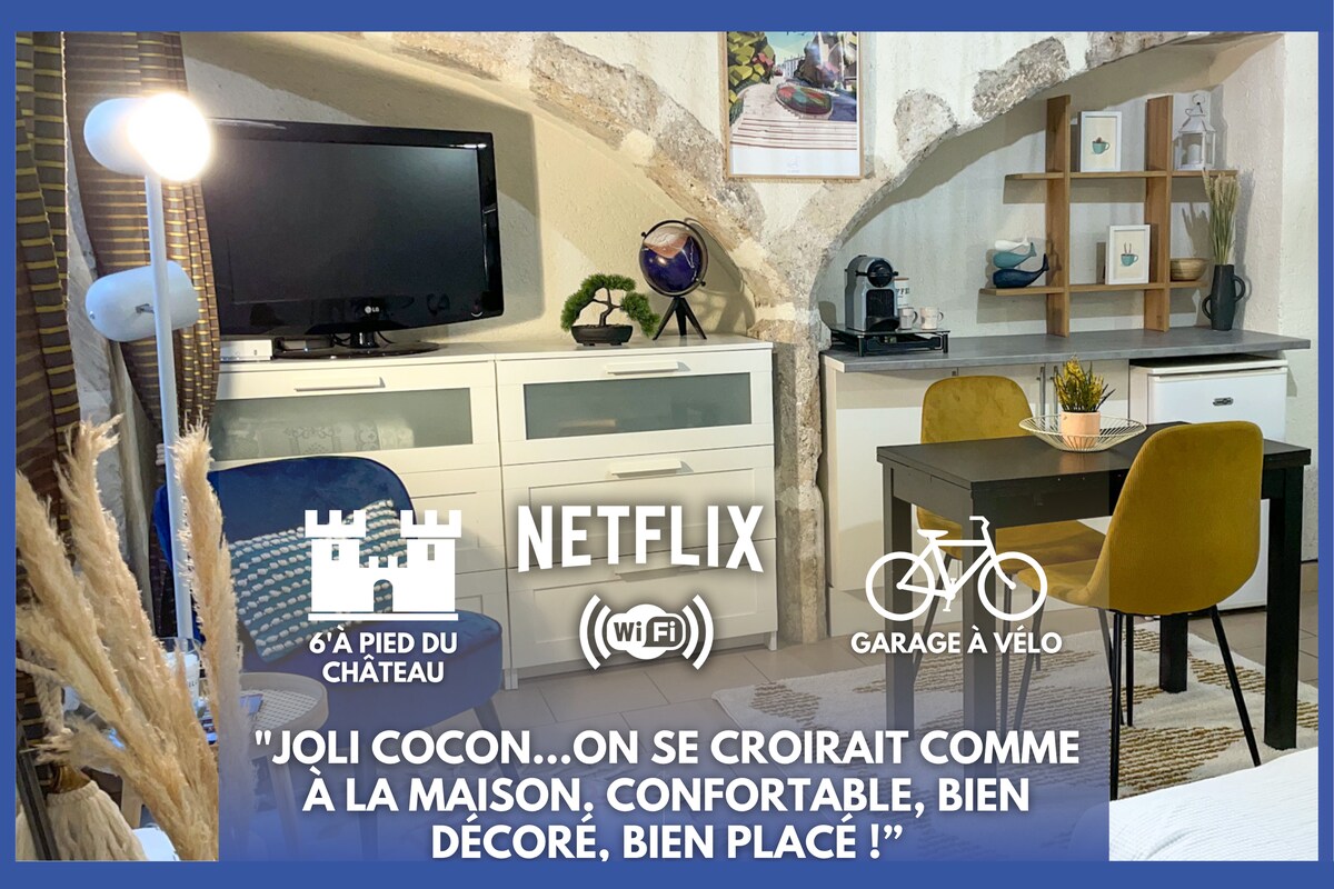 The image displays a cozy living space with a television and a small desk in front of a white wall. A stylish cabinet and a shelf with decorative items provide storage. A bicycle symbol indicates bike storage availability, while a Wi-Fi symbol highlights internet access.