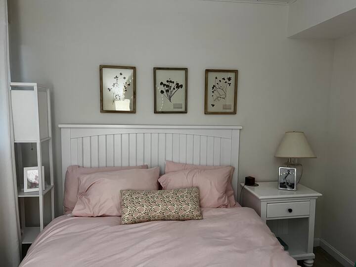 تتميز غرفة النوم الثانية بديكور ساحلي حديث ونظام خزانة مثبت حديثًا من متجر الحاويات، مما يوفر الراحة والاسترخاء.