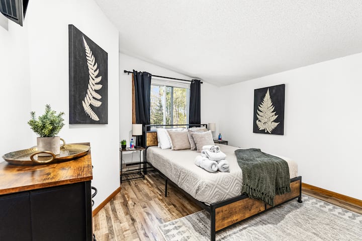 This charming bedroom features a comfortable queen bed and stunning views of the lake, perfect for waking up to nature’s beauty. Enjoy restful nights with blackout curtains that ensure a peaceful sleep, allowing you to recharge after a day of fun.