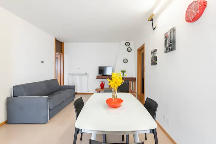 the interior living room, you can immediately see the large glass table, the sofa bed, the exposed fireplace and the TV