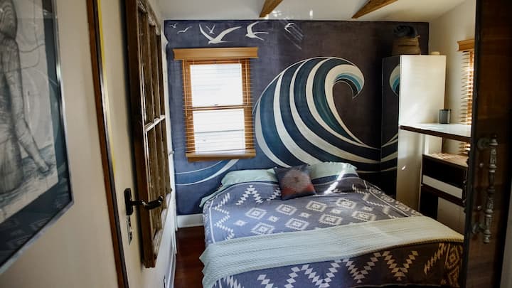 El segundo dormitorio / oficina/estudio con cama hecha como una cama tamaño king.