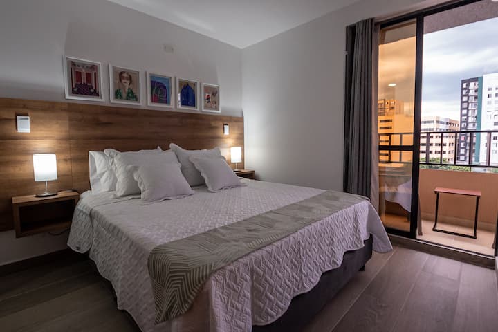De grote kamer opent naar het balkon, waar een comfortabel bed en een moderne, stijlvolle inrichting een sereen toevluchtsoord creëren voor een echt aangenaam verblijf.