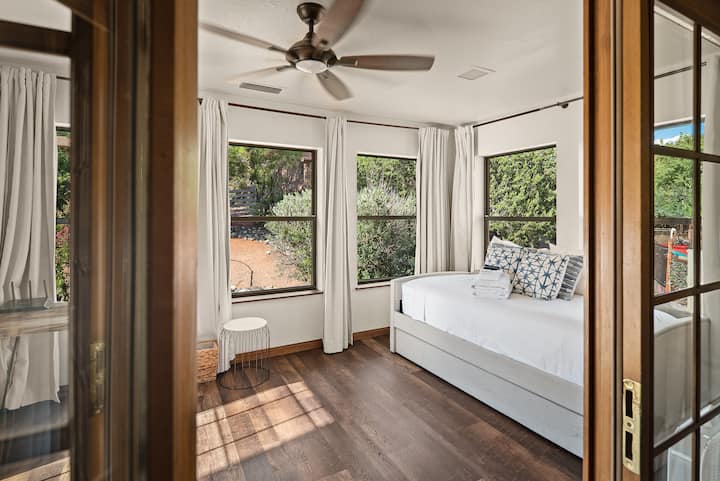 Bedroom 2, a chic sleeping nook with a twin trundle bed, is connected to Bedroom 1 by these beautiful wooden doors. The second twin bed slides out from under the bed.