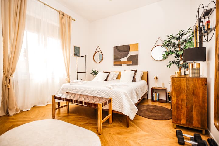 Glavna spavaća soba „Firenze” s bračnim krevetom, ogledalom, ormarom s odjećom, velikim prozorima  i stropnim ventilatorom. 