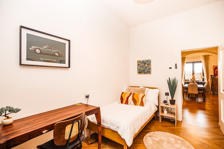 Soba „Siena” s krevetom za jednu osobu, stropnim ventilatorom na uvlačenje, radnim stolom, stalkom za odjeću + spremištem i velikim ogledalom. 