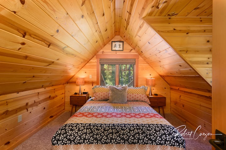Upstairs bedroom with river views from all windows. Each bedroom has an alarm clock with wireless phone charger and Bluetooth stereo speaker.  There are also wired phone charging cords in the nightstands with all necessary adapters.
