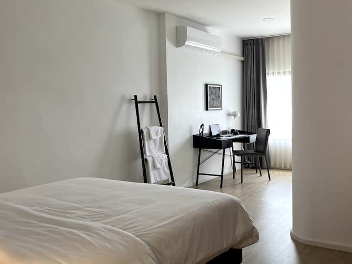 Bright and peaceful bedroom featuring a comfortable bed and a dedicated workspace. Perfect for both relaxation and productivity, with plenty of natural light to create a calming atmosphere for your stay.